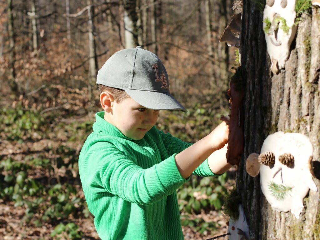 Volle Konzentration beim Gestalten der Baumgesichter - Kreativ-Idee für Kinder